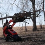 skid steer mini skeleton grapple picking up branches
