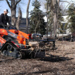 mini grapple picking up brush