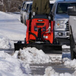 mini snow blade clearing sidewalk