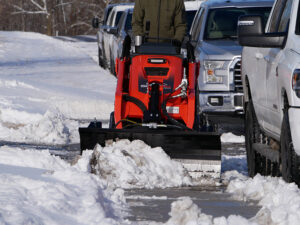 mini snow blade clearing sidewalk